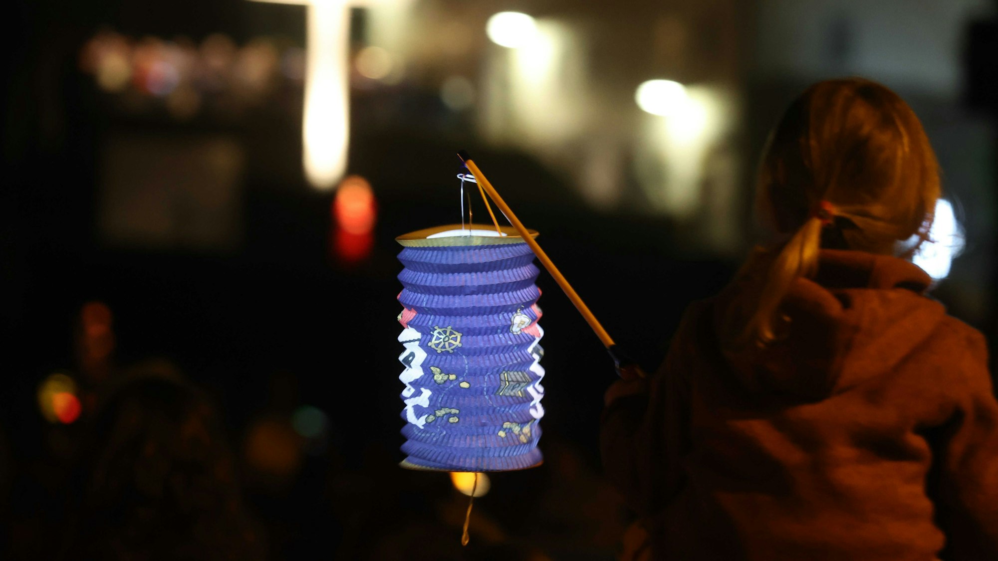 Ein Kind hält eine Laterne bei einer Martinsfeier. Aussagen der FDP-Politikerin Katja Adler ließen das Thema „St. Martin“ am Dienstag und Mittwoch in den sozialen Netzwerken trenden. (Archivbild)