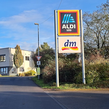 In einem Gewerbegebiet in Niederkassel-Mondorf weist eine Werbetafel auf die Filiale des Discounters Aldi hin.