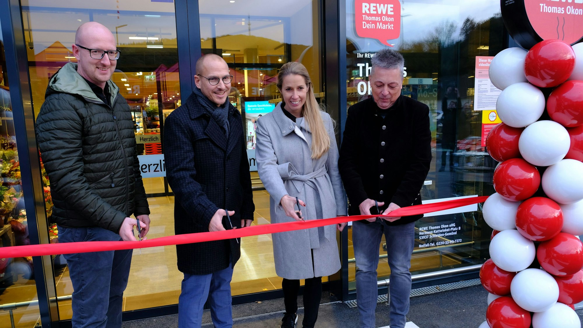 Neueröffnung des Rewe-Markts Gemünd mit (v.l.) Bürgermeister Ingo Pfennings, Rewe-Kaufmann Thomas Okon, Vertriebsleiterin Carina Bruns und Rewe-West-Vorstand Uwe Hoeveler, die ein rotes Band durchtrennen.