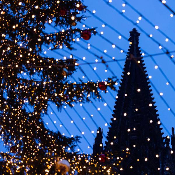 Köln: Die Domspitzen sind hinter Beleuchtung des Weihnachtsmarkts auf dem Roncalliplatz zu sehen.