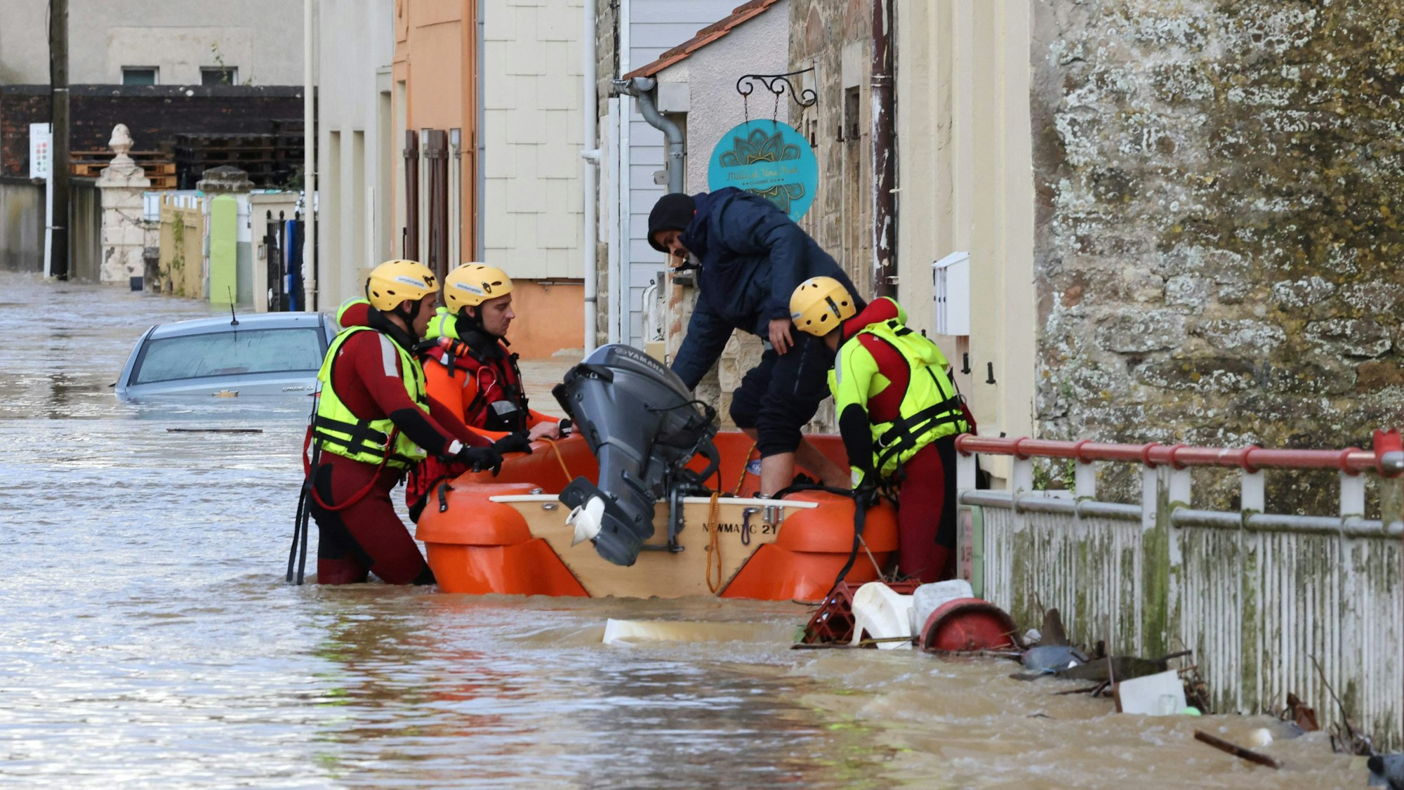 Französische Feuerwehrleute retten eine Person an einem überschwemmten Haus mit einem Rettungsboot. Besonders der Norden Frankreichs ist hart von Unwettern und Überschwemmungen getroffen.