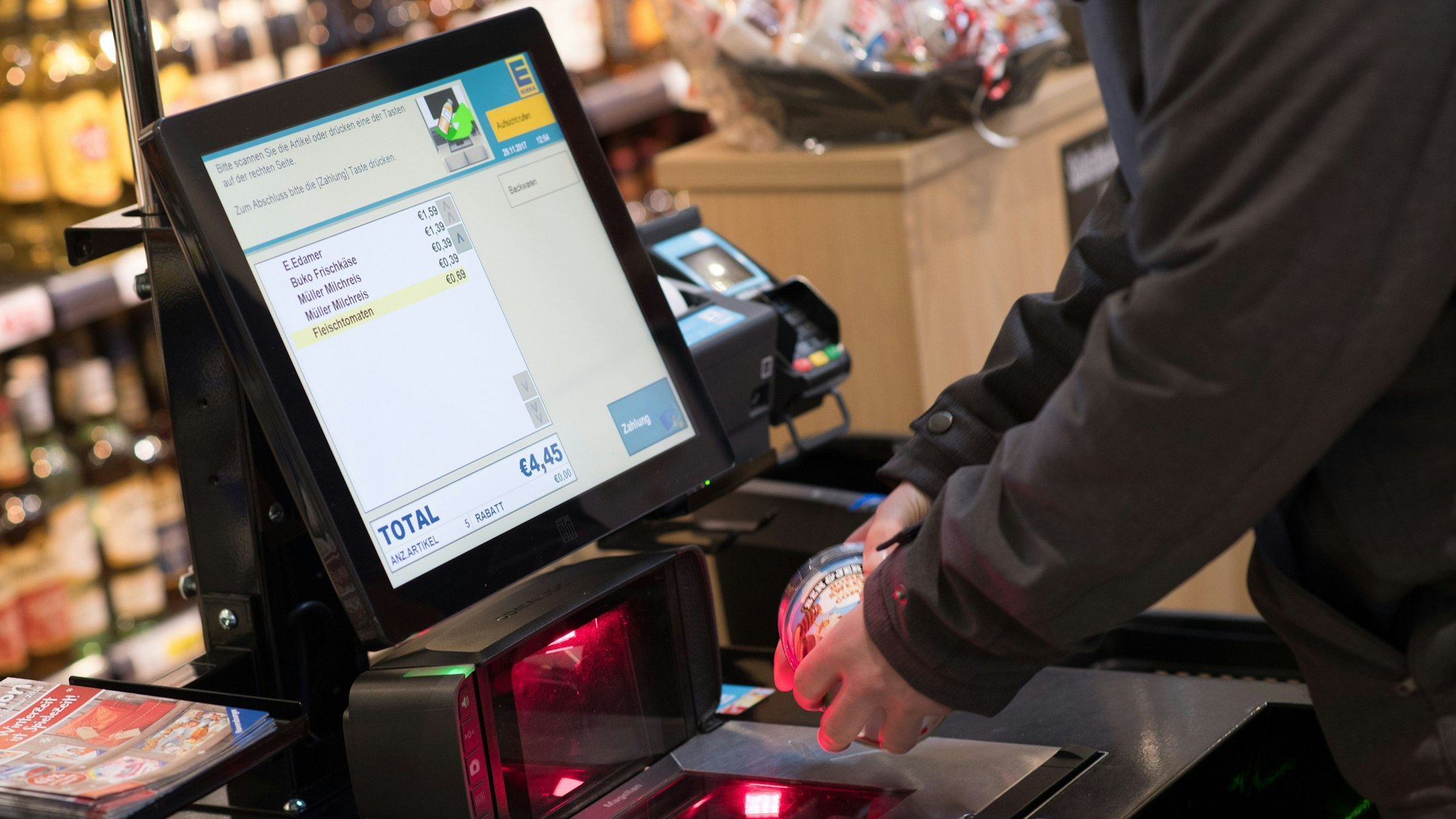 Ein Mann scannt im Edeka-Markt in Kassel Lebensmittel an einer SB-Kasse. (Archivbild)
