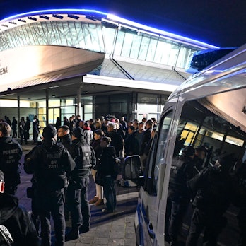 Solo-Konzert von Till Lindemann in Leipzig: Polizisten blicken auf den Gegenprotest, der sich gegen den Rammstein-Sänger stellt.