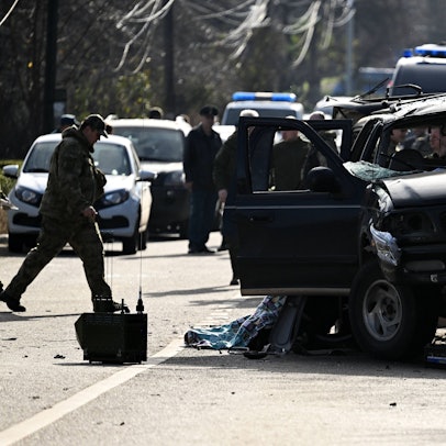 Einsatzkräfte stehen hinter einem ramponierten LKW.
