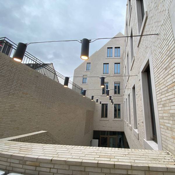 Zu sehen ist der von Lampen beleuchtete Lichthof des Rathausanbaus.