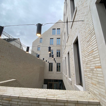 Zu sehen ist der von Lampen beleuchtete Lichthof des Rathausanbaus.