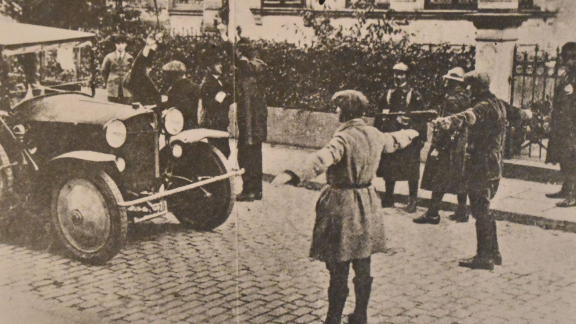 Zwei Männer stehen mit ausgebreiteten Armen auf einer Straße und halten den Verkehr an.