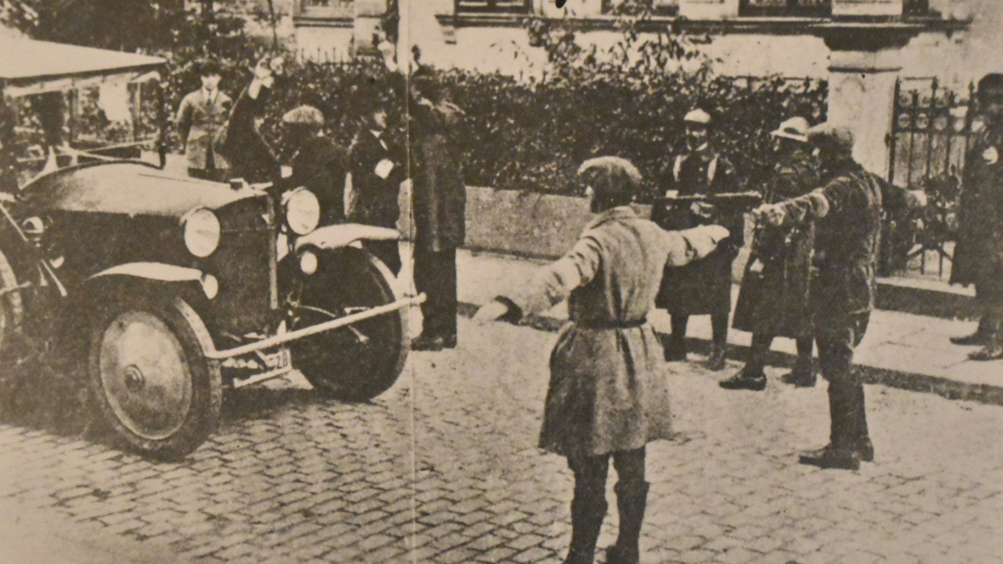 Zwei Männer stehen mit ausgebreiteten Armen auf einer Straße und halten den Verkehr an.