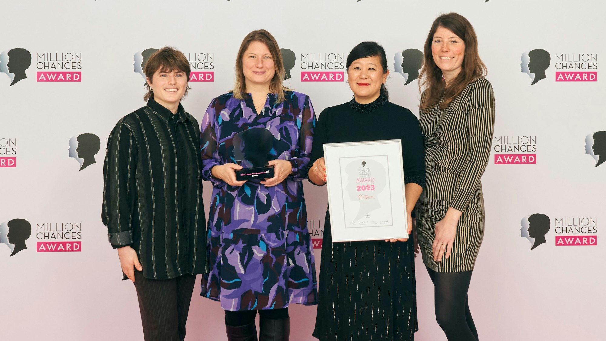 Vier Frauen mit einer Urkunde.