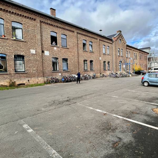 Das ehemalige Casino an der Friedrich-Wilhelm-Straße in Mechernich dient als Unterkunft für Geflüchtete. Vor dem Gebäude stehen zahlreiche Fahrräder und ein paar Autos.