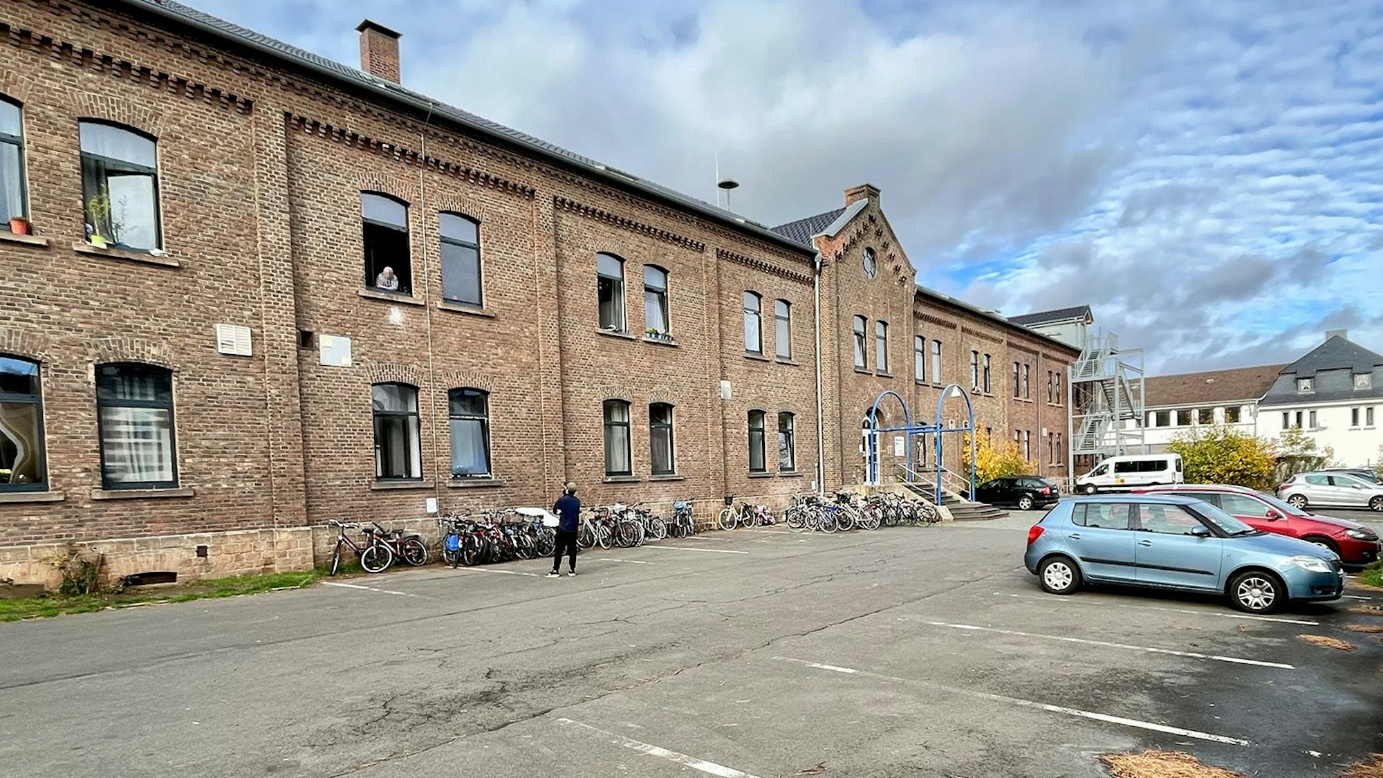 Das ehemalige Casino an der Friedrich-Wilhelm-Straße in Mechernich dient als Unterkunft für Geflüchtete. Vor dem Gebäude stehen zahlreiche Fahrräder und ein paar Autos.