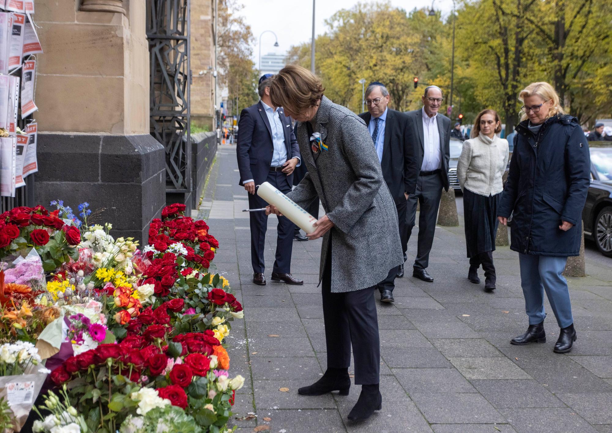 Henriette Reker, Oberbürgermeisterin von Köln, stellt im Beisein von Abraham Lehrer, Vorstand der Synagogen-Gemeinde Köln, eine Kerze vor der Synagoge auf.