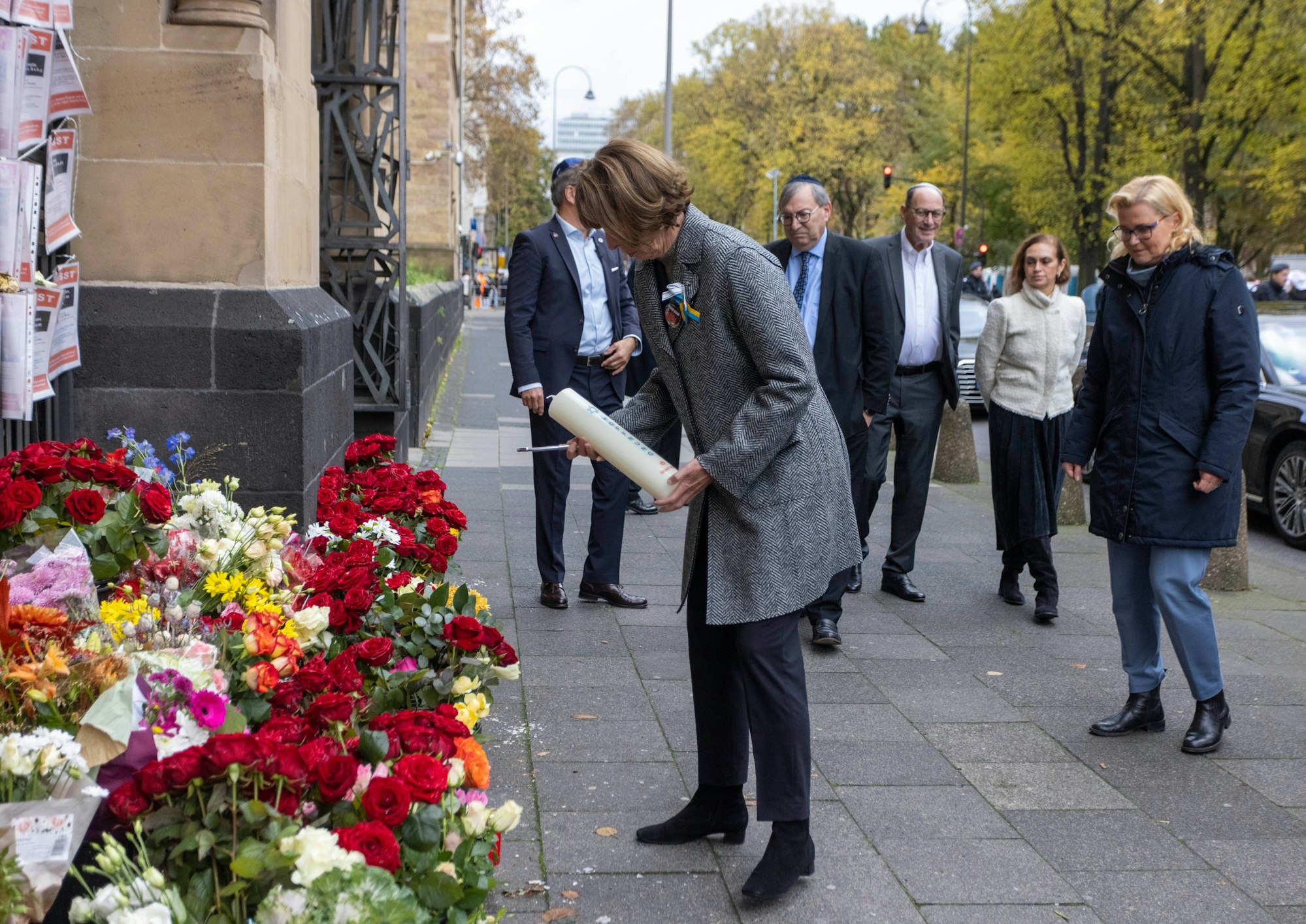 Henriette Reker, Oberbürgermeisterin von Köln, stellt im Beisein von Abraham Lehrer, Vorstand der Synagogen-Gemeinde Köln, eine Kerze vor der Synagoge auf.