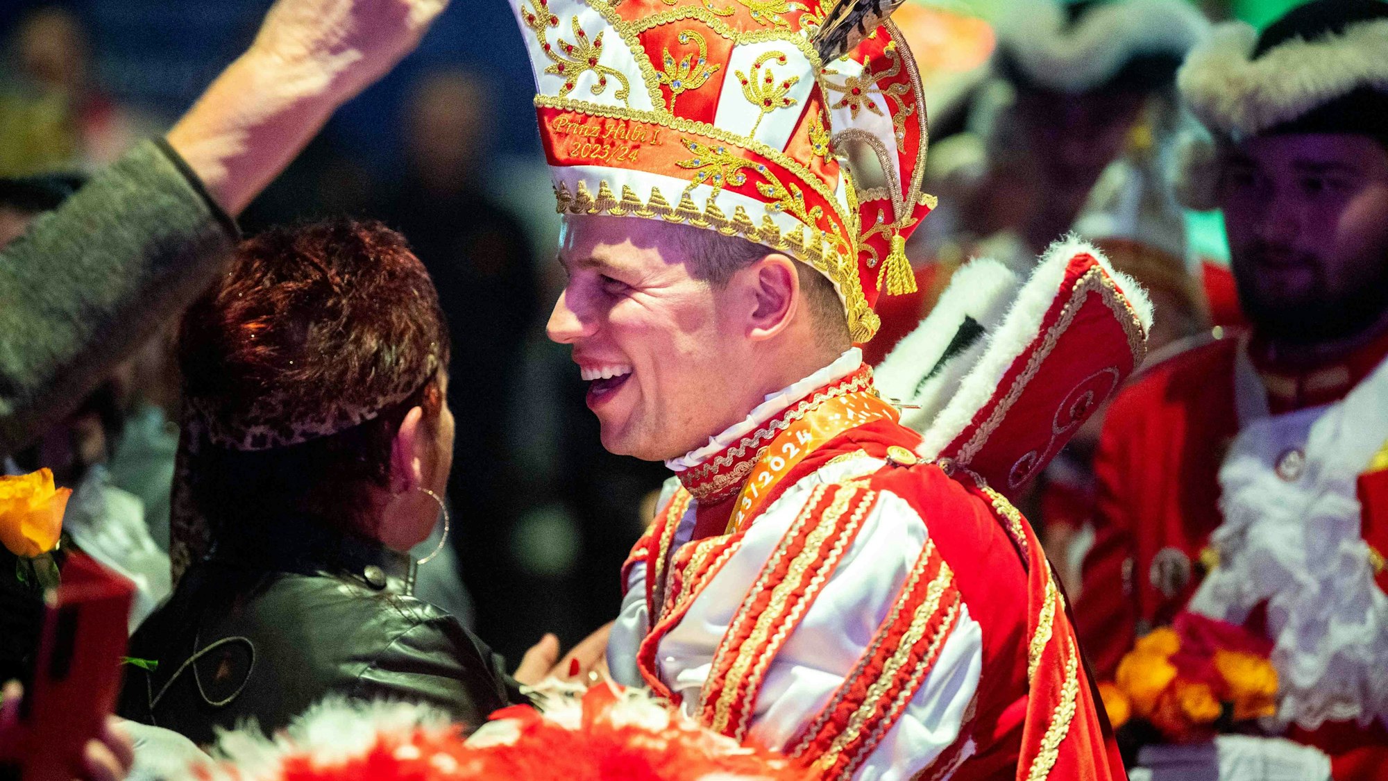 Das Bild zeigt Hubertus Bollig, der lächelt und Bützjer verteilt.