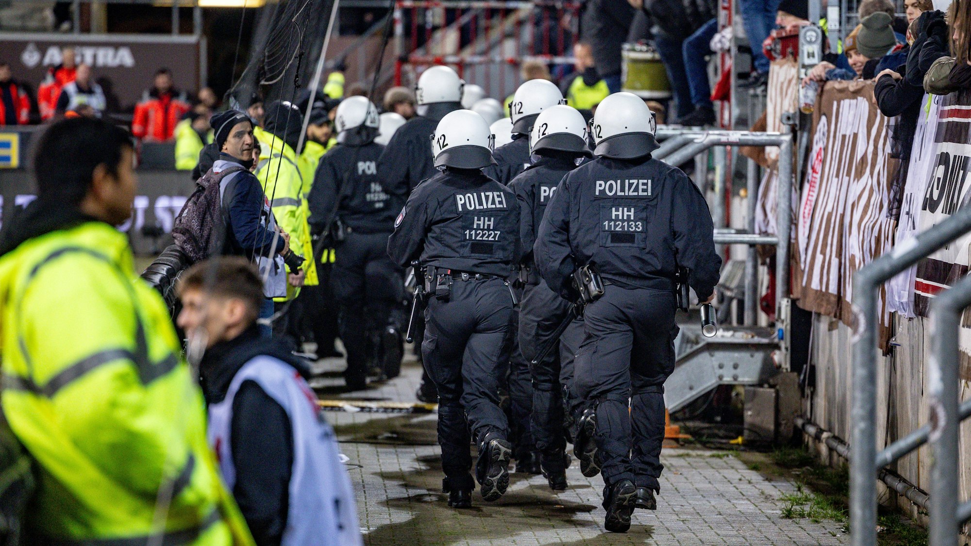 10.11.2023, Hamburg: Fußball: 2. Bundesliga, FC St. Pauli - Hannover 96, 13. Spieltag, Millerntorstadion. Einsatzkräfte der Polizei laufen auf den Fanblock der Hannoveraner zu. Foto: Axel Heimken/dpa - WICHTIGER HINWEIS: Gemäß den Vorgaben der DFL Deutsche Fußball Liga bzw. des DFB Deutscher Fußball-Bund ist es untersagt, in dem Stadion und/oder vom Spiel angefertigte Fotoaufnahmen in Form von Sequenzbildern und/oder videoähnlichen Fotostrecken zu verwerten bzw. verwerten zu lassen. +++ dpa-Bildfunk +++