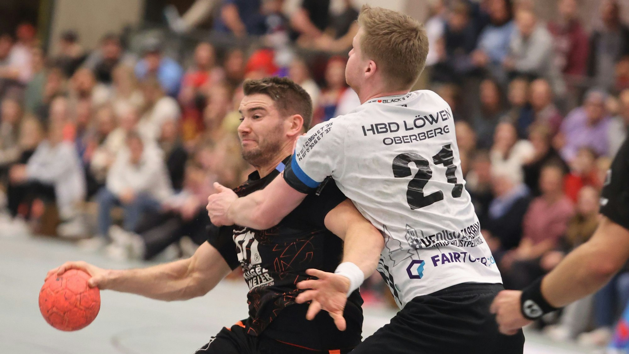 Nümbrechts Tim Hartmann wird mit dem Ball in der Hand von seinem Gegenspieer gestoppt.