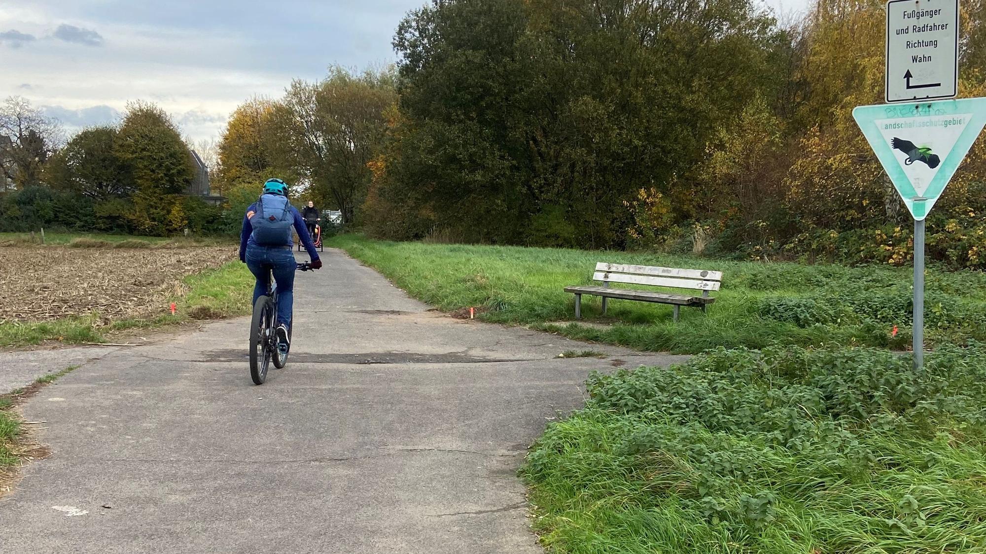 Ein Radfahrer ist auf einem Radweg inmitten von Feldern unterwegs.