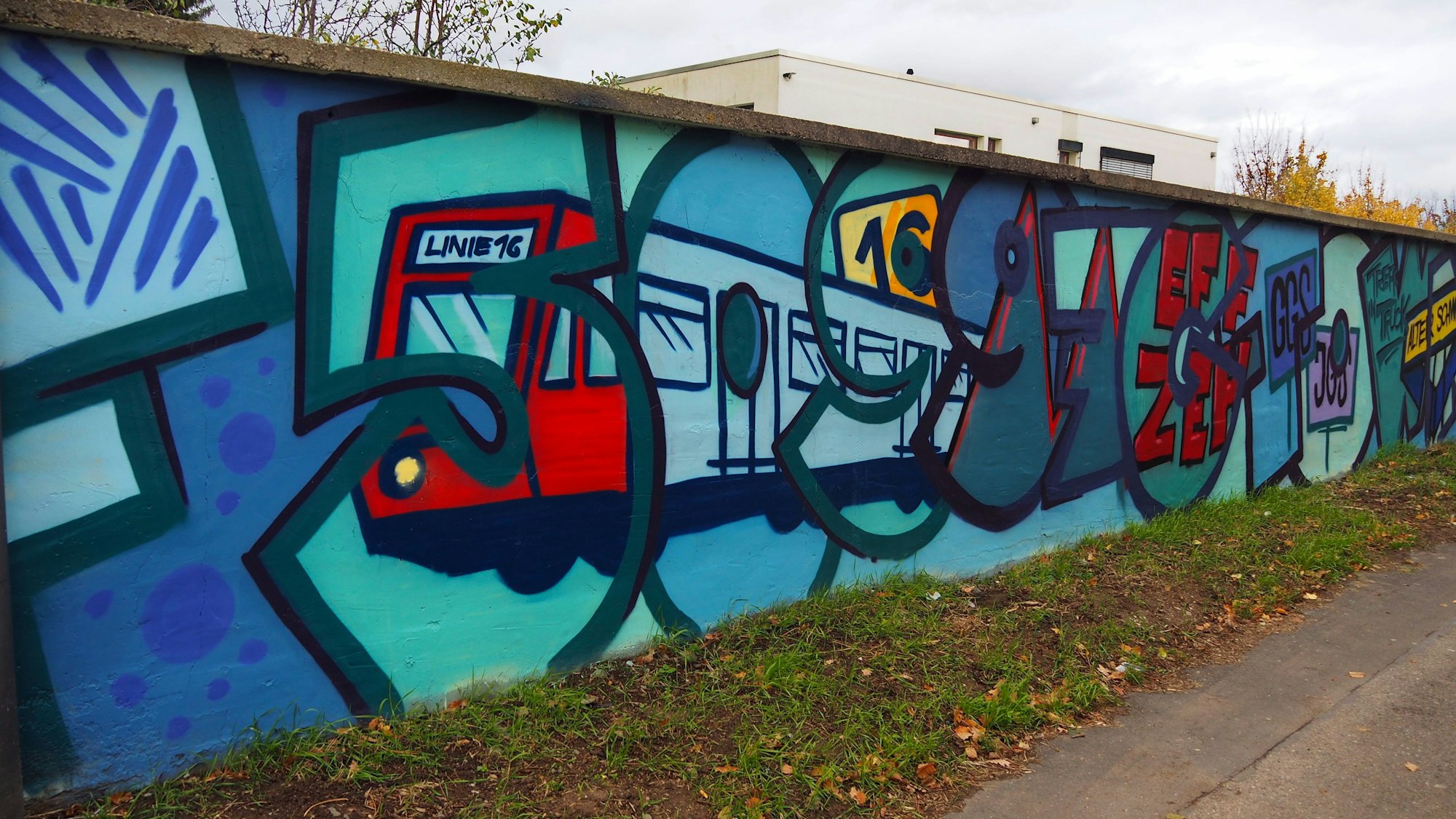 Bunte Motive, darunter die KVB-Bahn mit der Nummer 16 sind auf eine Wand gesprüht.