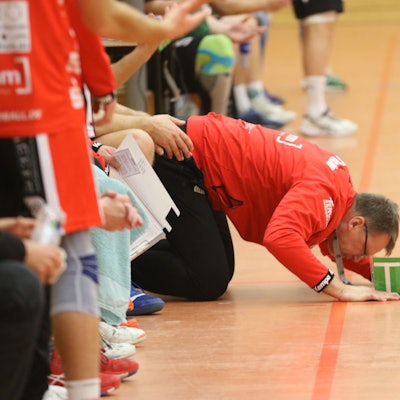 HSG-Euskirchen-Trainer Marco Matheis kniet auf dem Boden, den Kopf fast auf dem Parkett liegend.