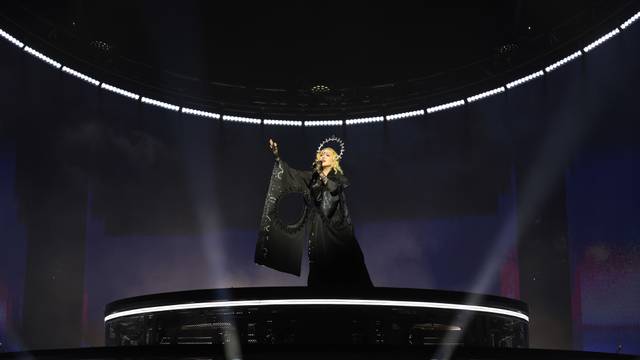 Madonna trägt schwarzes Kleid und Heiligenschein.