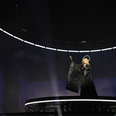 Madonna trägt schwarzes Kleid und Heiligenschein.