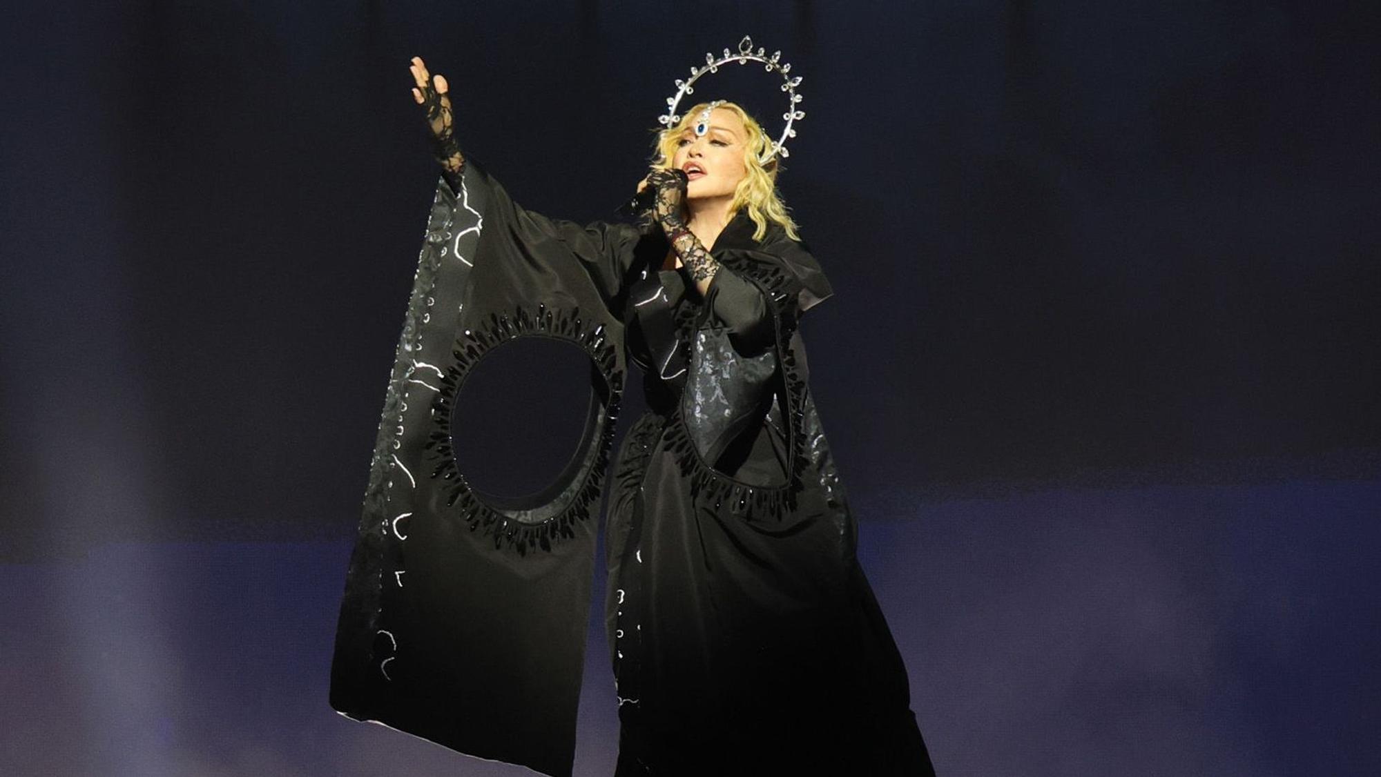 Madonna trägt schwarzes Kleid und Heiligenschein.