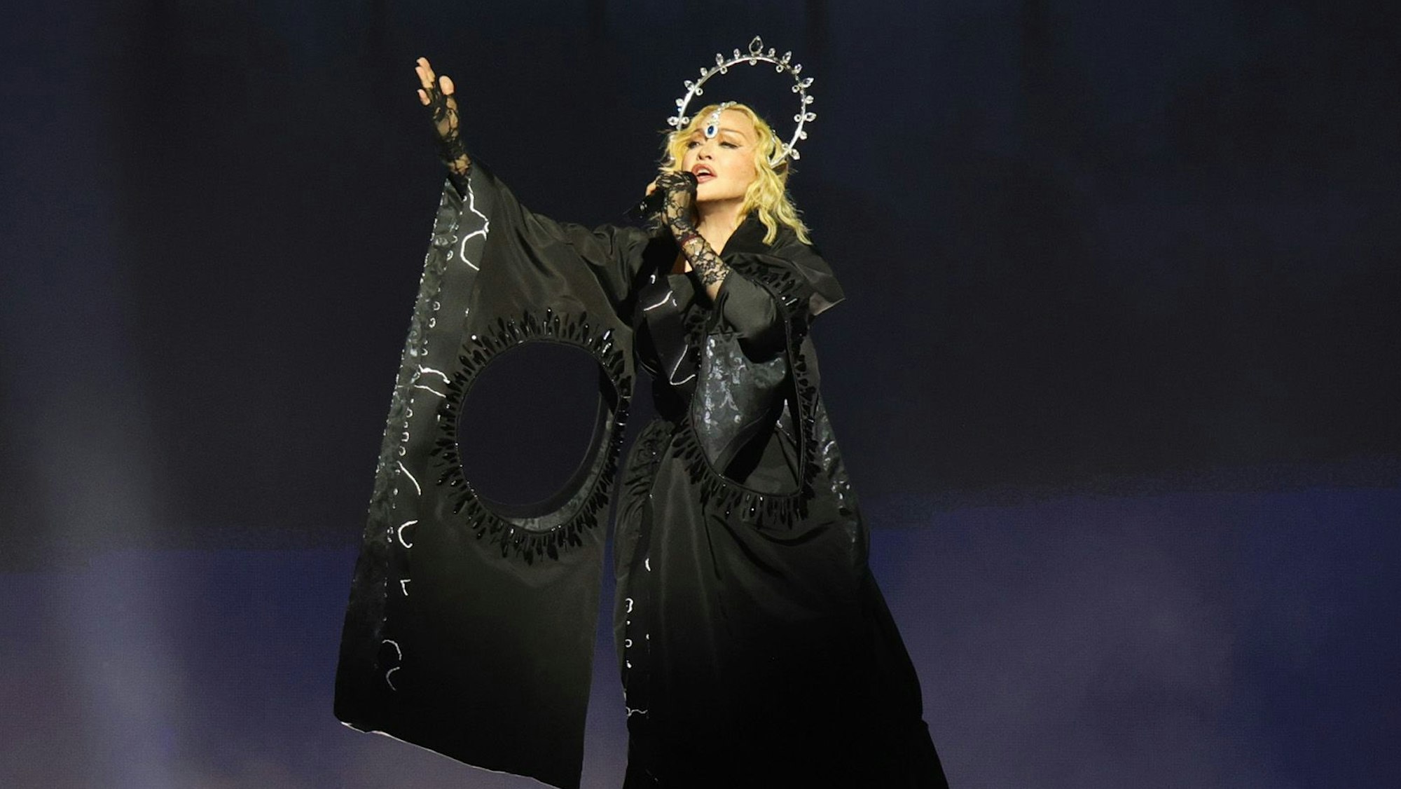Madonna trägt schwarzes Kleid und Heiligenschein.