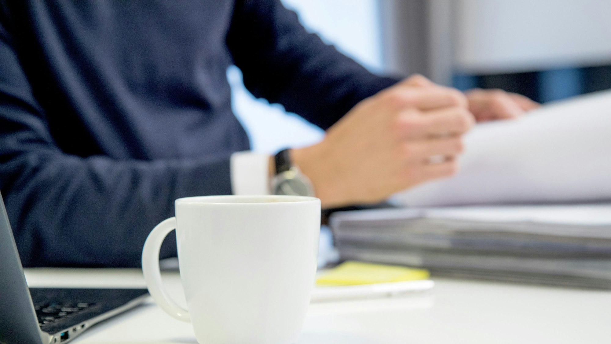 Ein Angestellter sitzt an seinem Schreibtisch.