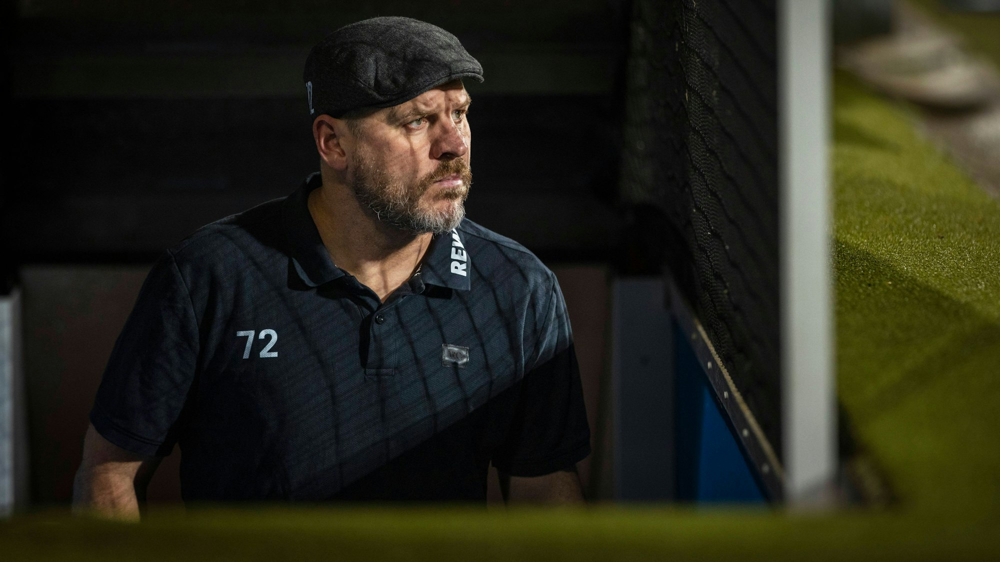 Steffen Baumgart sitzt im Dunkeln, schaut grimmig zur Seite.