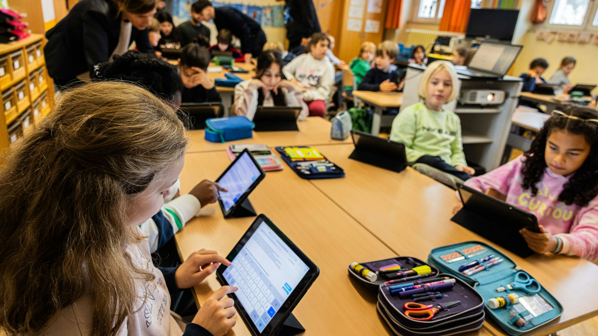 Schülerinnen und Schüler mit iPads in einem Klassenzimmer.