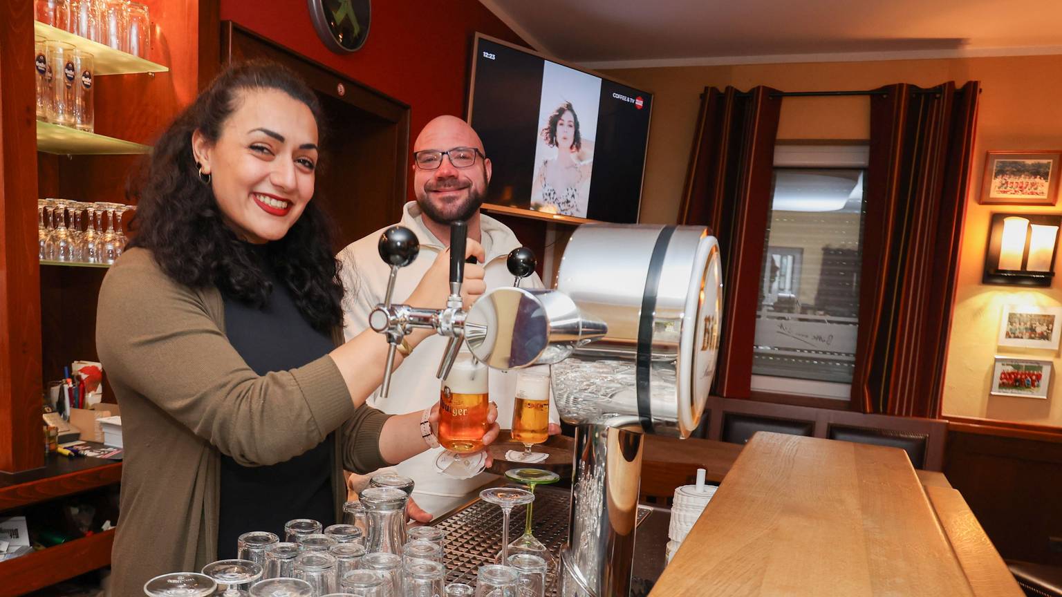 Maria Ghaffari und Patrick Hormann beim Bierzapfen in der Theke der Lindenstube in Wachtberg Berkum.