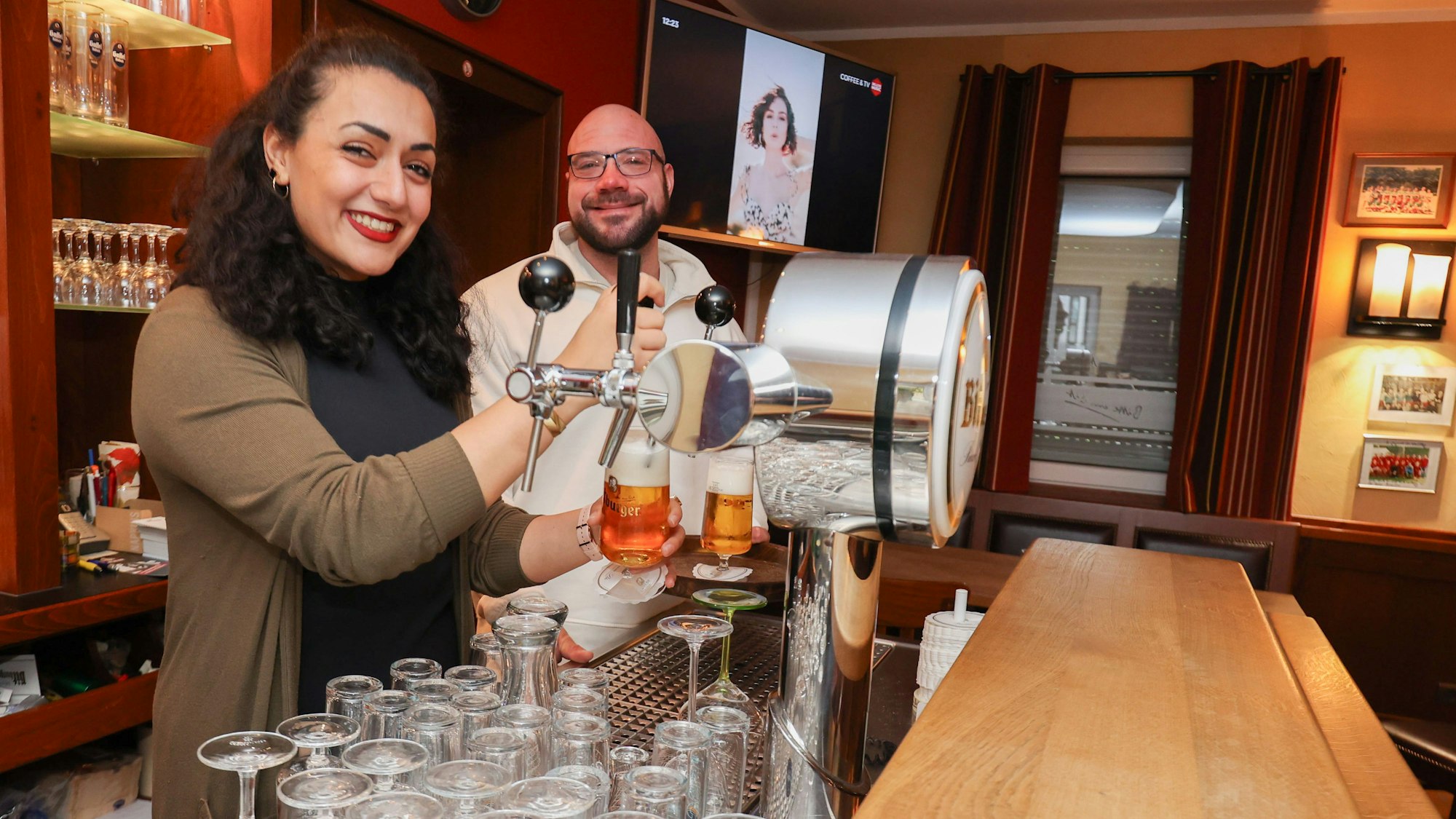 Maria Ghaffari und Patrick Hormann beim Bierzapfen in der Theke der Lindenstube in Wachtberg Berkum.