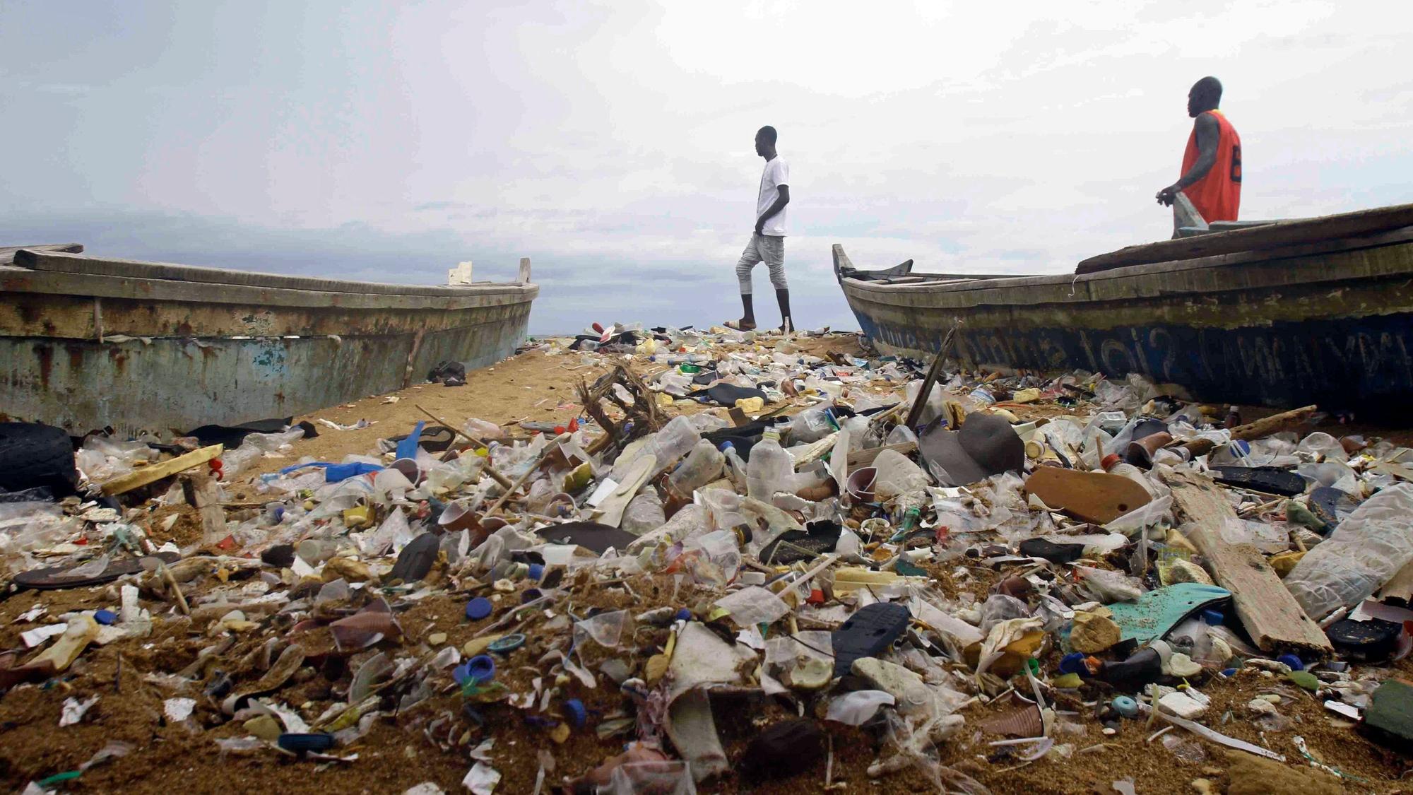 Menschen spazieren am 2. Juni 2023 über den mit Plastik verschmutzten Strand von Port Bouet außerhalb von Abidjan, Elfenbeinküste.