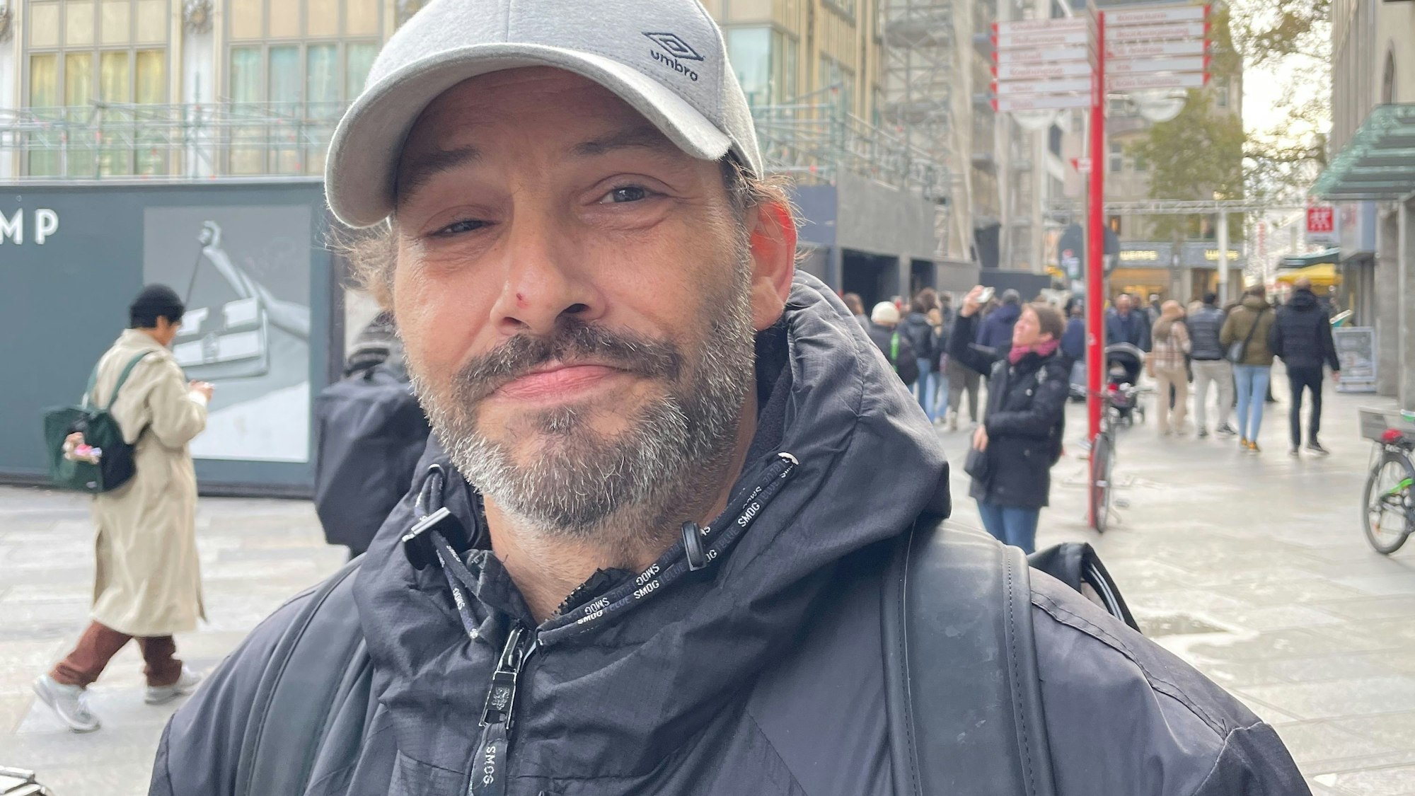 Ein Mann mit grauer Kappe steht vor dem Dom