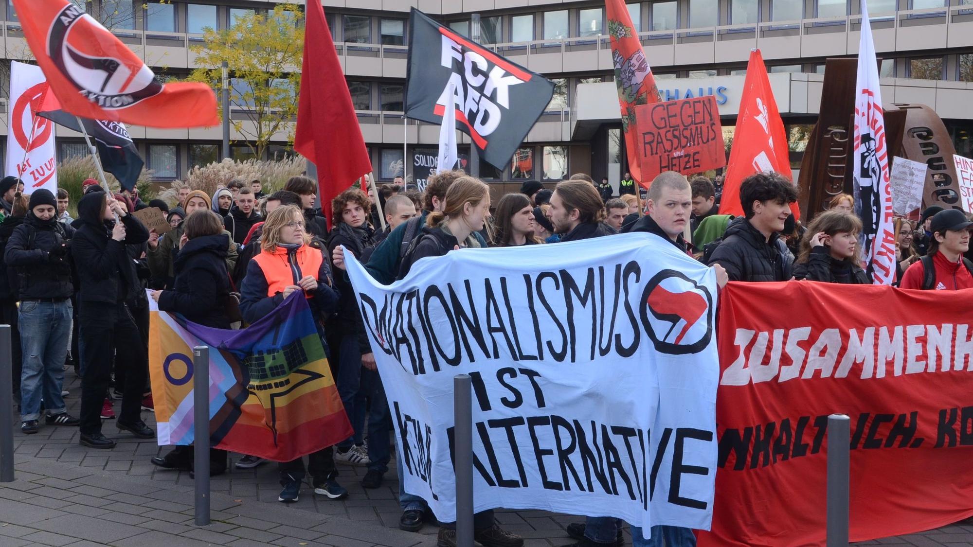 Demonstranten vor der Stadthalle, im Hintergrund ist das Troisdorfer Rathaus zu sehen. Die Demonstranten tragen Transparente mit Aufschriften wie „Nationalismus ist keine Alternative“.