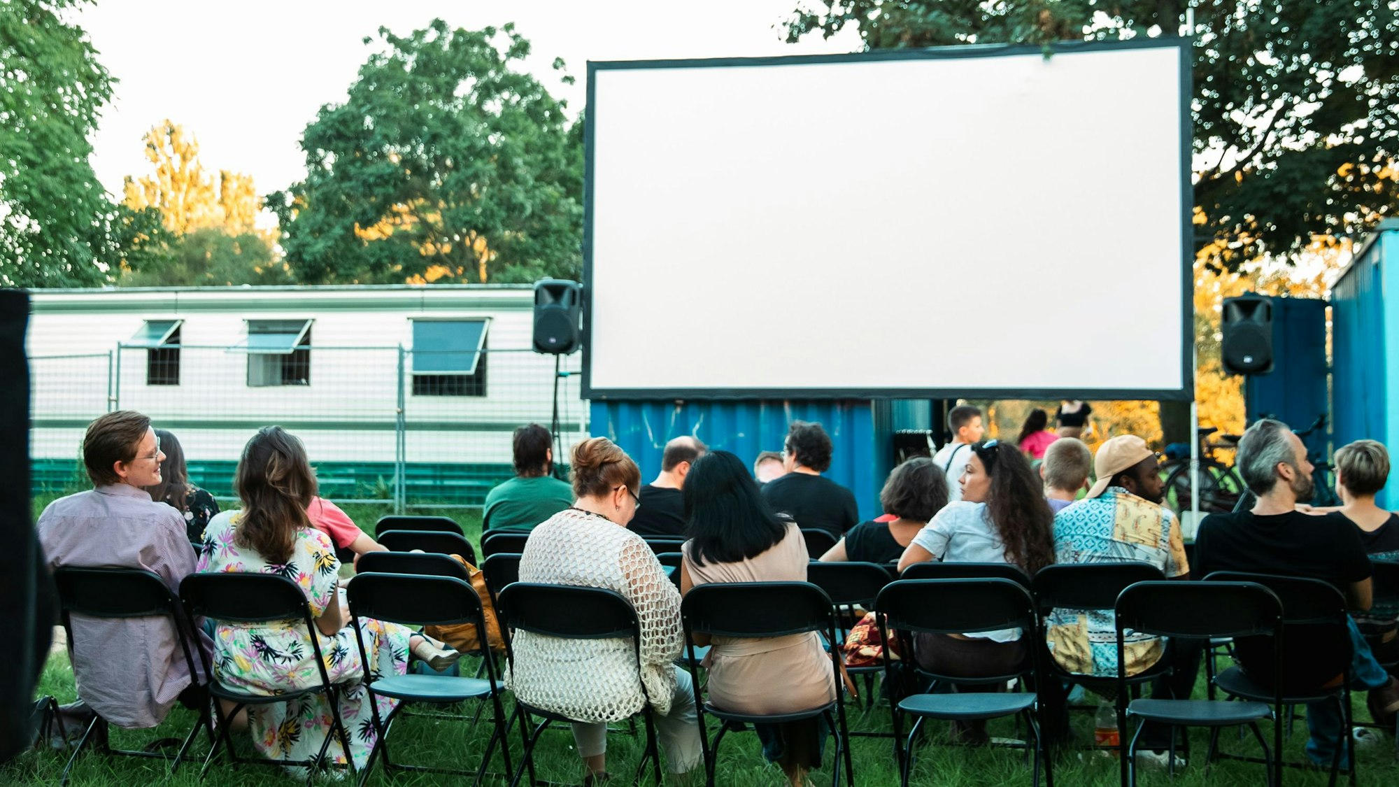 Zuschauer gucken auf eine Leinwand