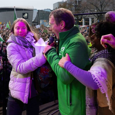 Erjan Dam (M.) und Greta Thunberg streiten am Sonntag (12. November) bei der Klima-Demo in Amsterdam ums Mikrofon.