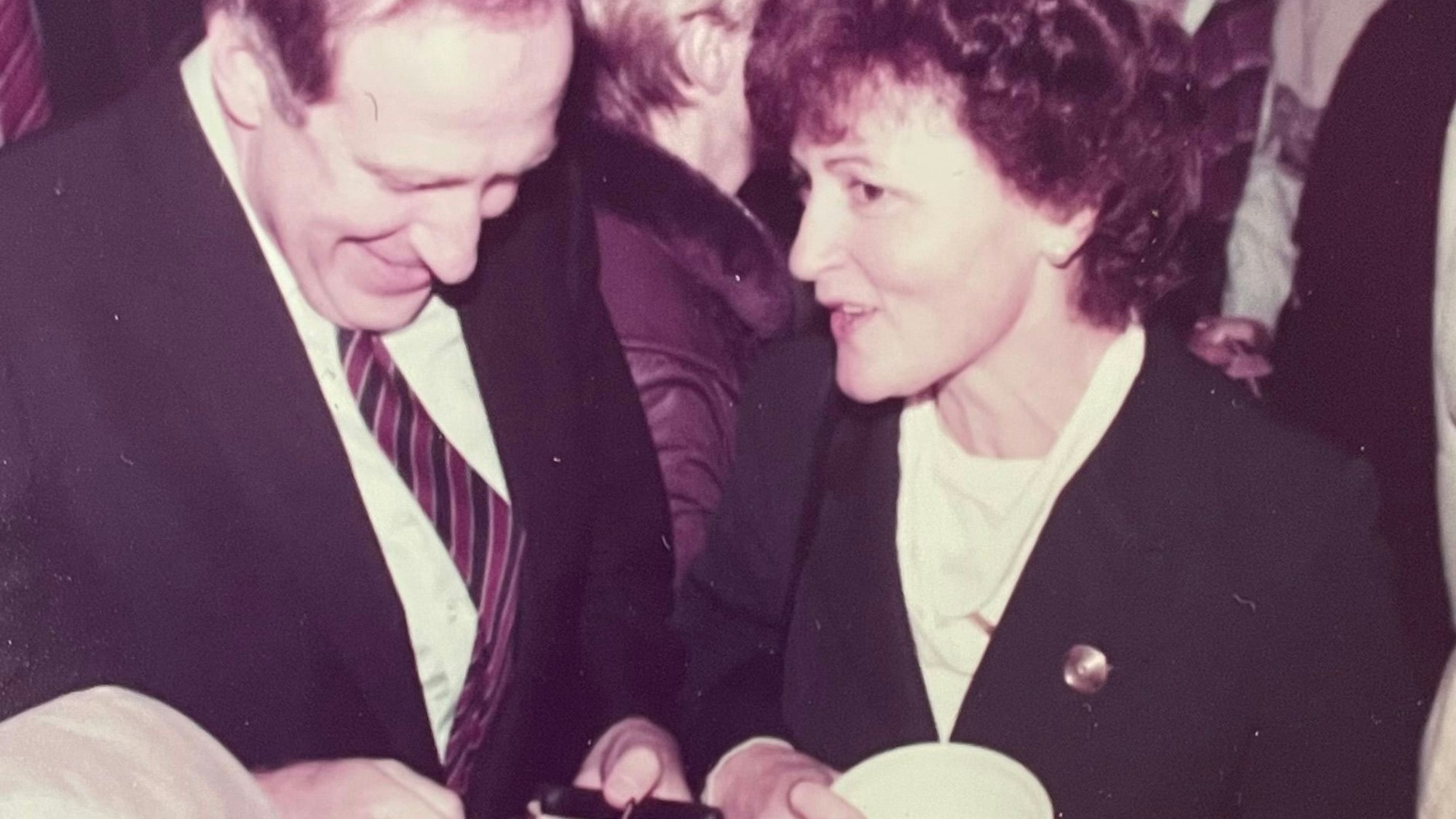 Auf einem Schwarz-Weiß-Bild sind ein Mann und eine Frau zu sehen, die sich unterhalten.