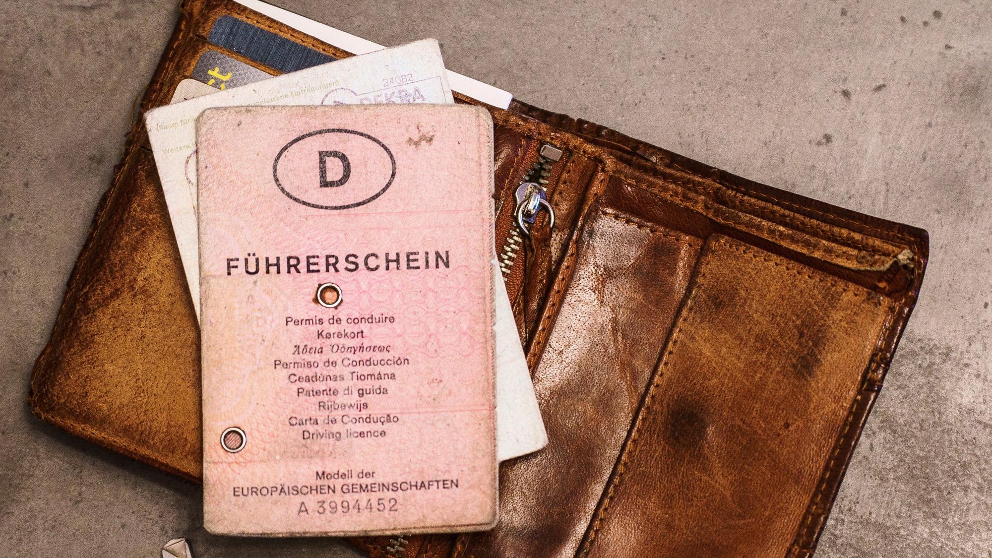 Ein ´rosa Führerschein», ein Autoschlüssel, eine Geldbörse und ein Fahrzeugschein liegen auf dem Tisch.