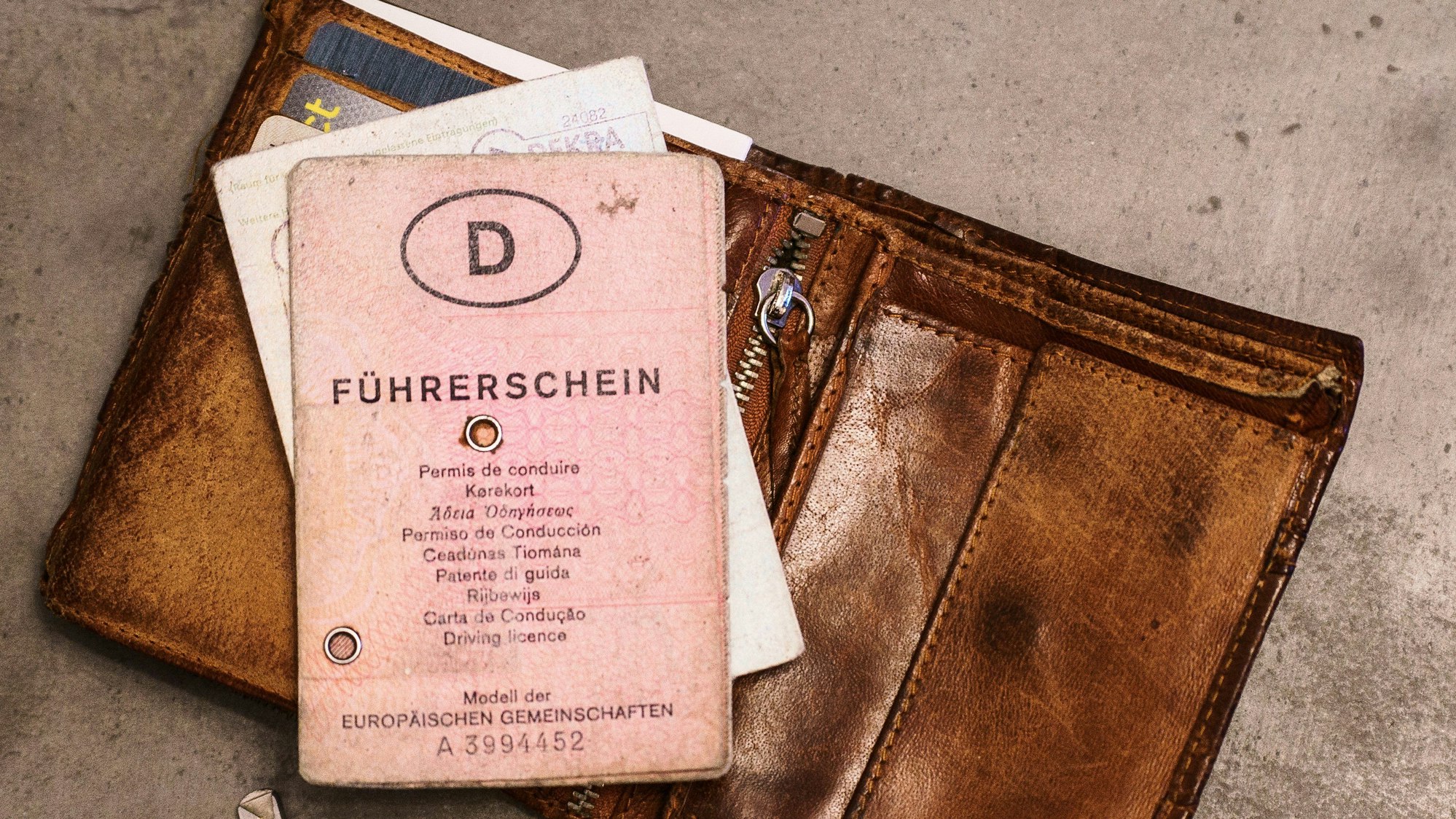 Ein ´rosa Führerschein», ein Autoschlüssel, eine Geldbörse und ein Fahrzeugschein liegen auf dem Tisch.
