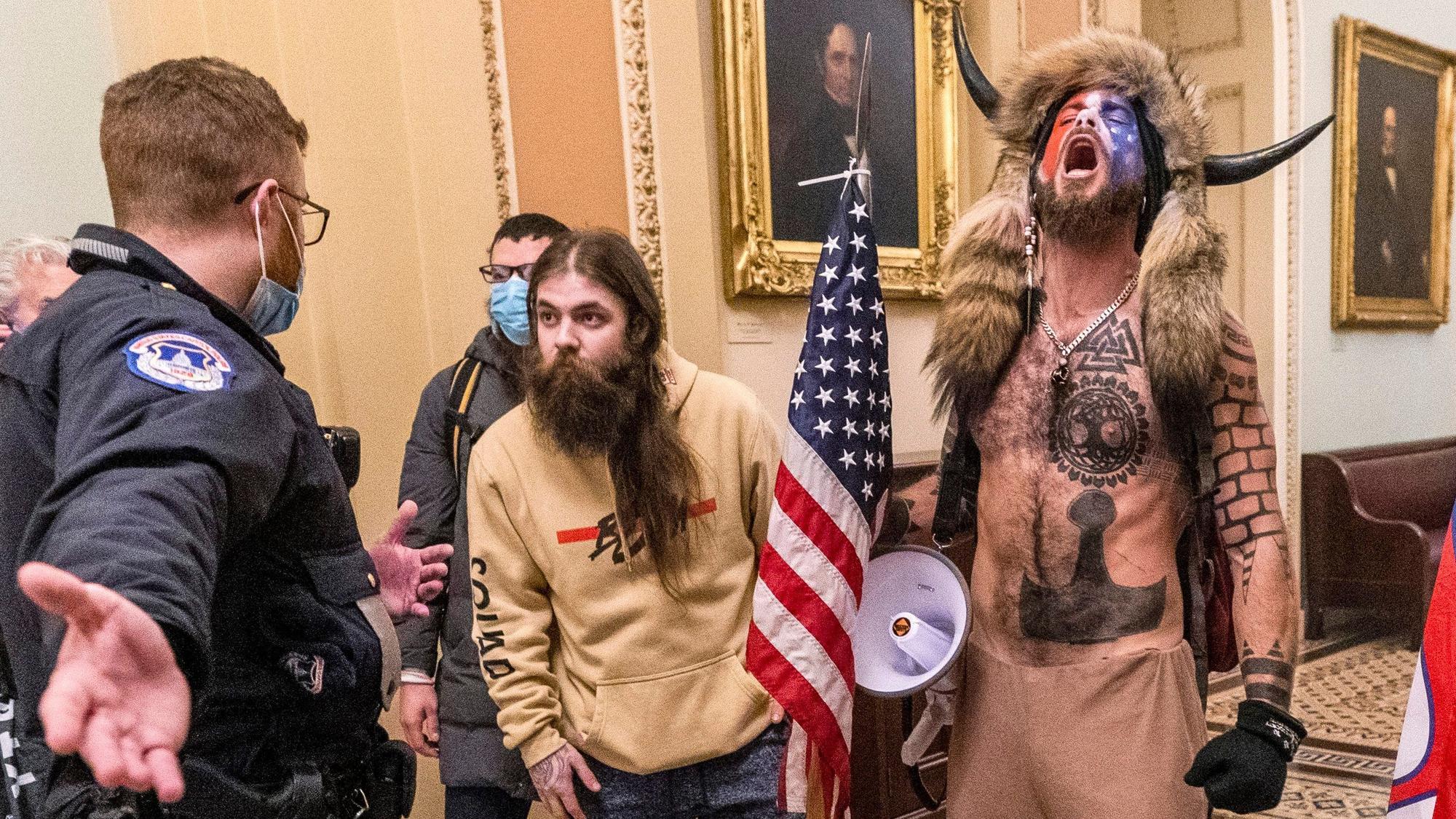 Der als „Q-Anon-Schamane“ bekannt gewordene Jacob Chansley (r.) wurde beim Sturm auf das US-Kapitol vielfach abgebildet. Nun will er bei den US-Kongresswahlen 2024 antreten. (Archivbild)