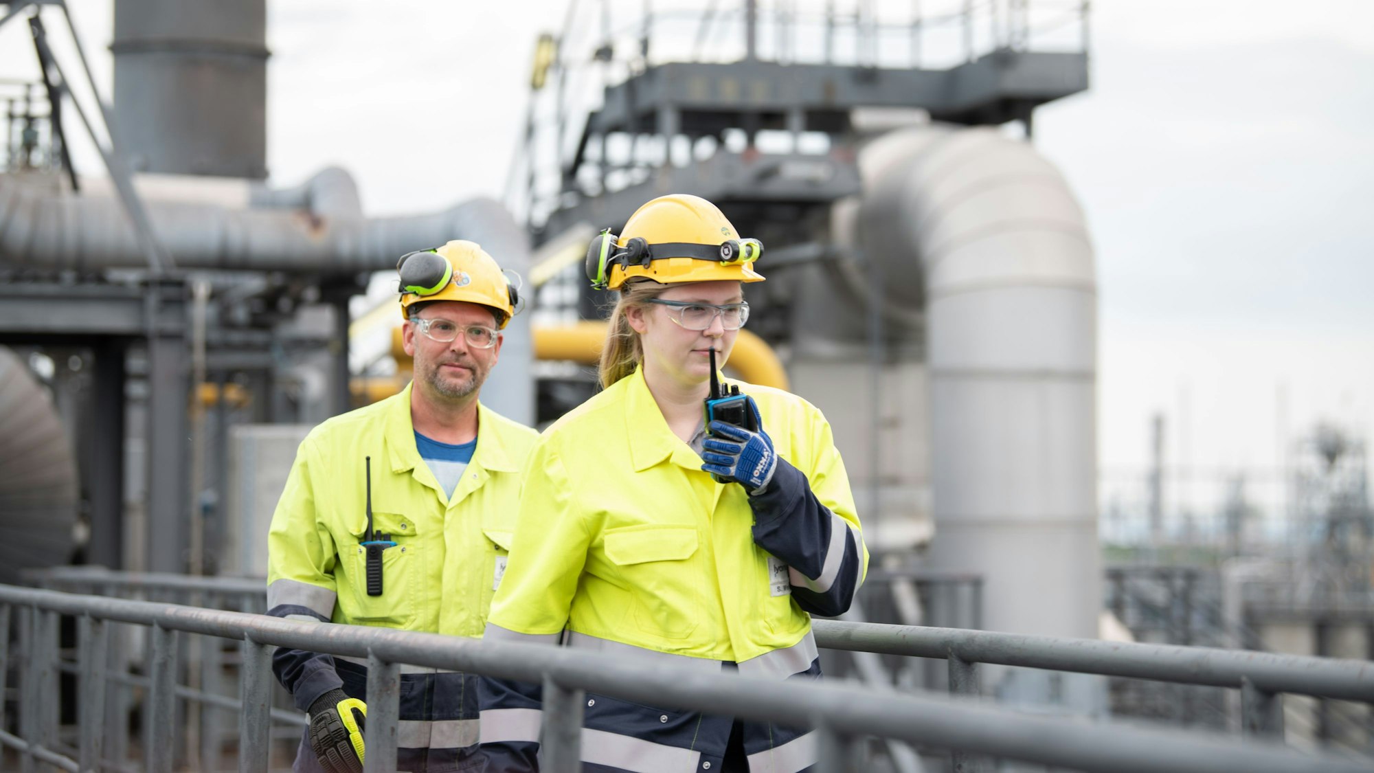 Zwei Menschen in gelber Arbeitskleidung.