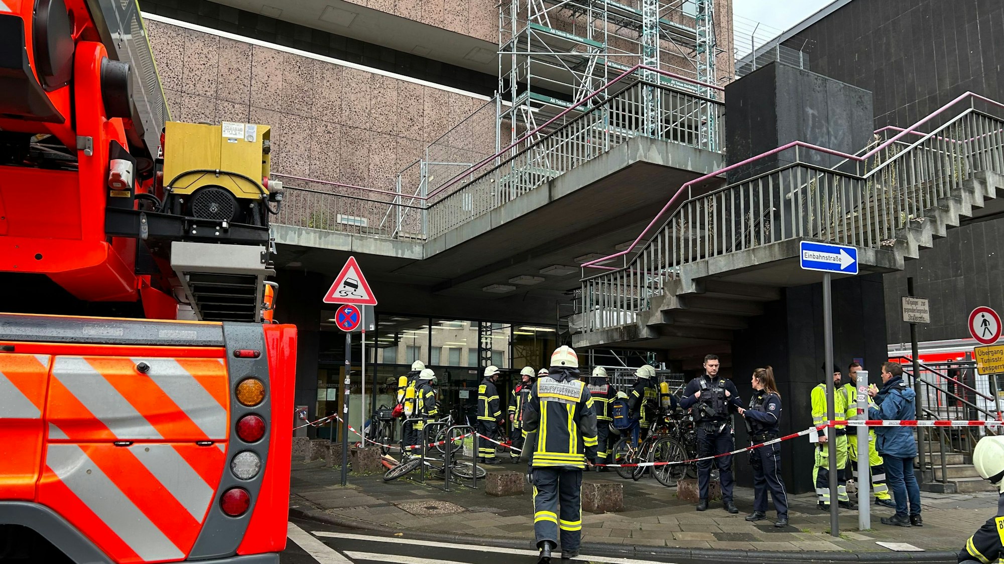 Feuerwehrleute und ein Feuerwehrwagen vor einem Bürogebäude.