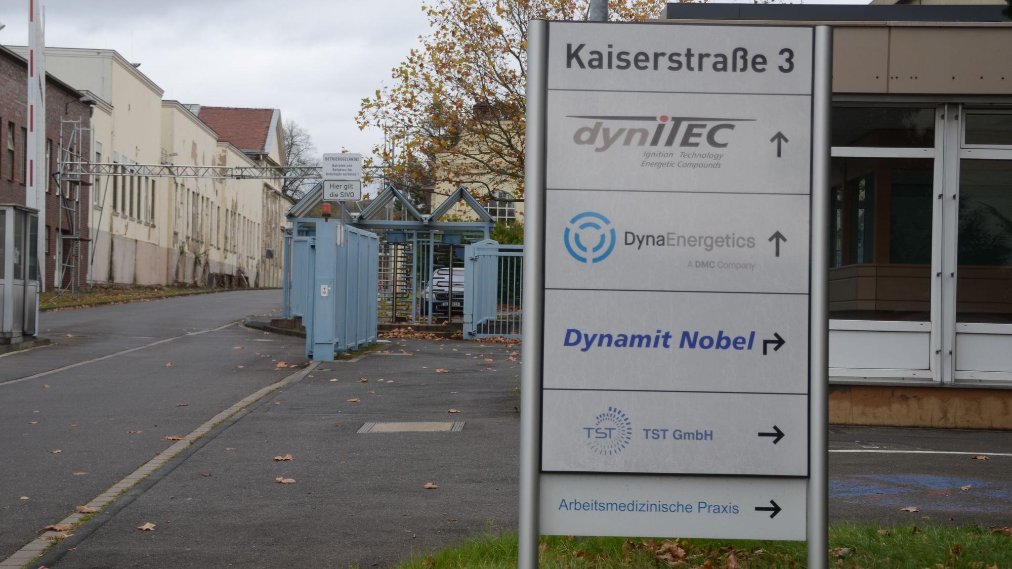 Die Einfahrt zu einem Industriepark. Auf einem Schild stehen mehrere Firmennamen.