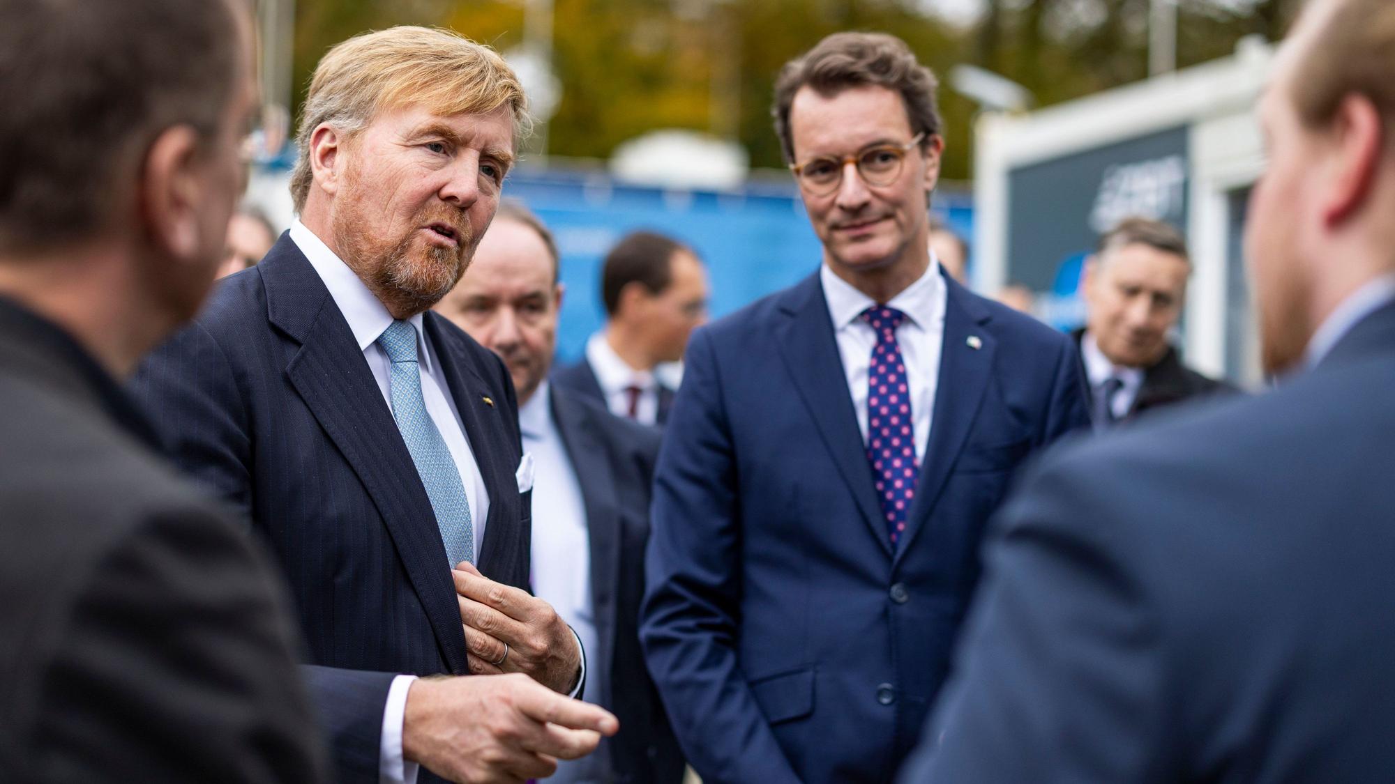 König Willem-Alexander der Niederlande (2.v.l.) und NRW-Ministerpräsident Hendrik Wüst unterhalten sich auf dem Gelände des ZBT der Universität Duisburg-Essen.