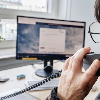 Eine Frau telefoniert am Schreibtisch.