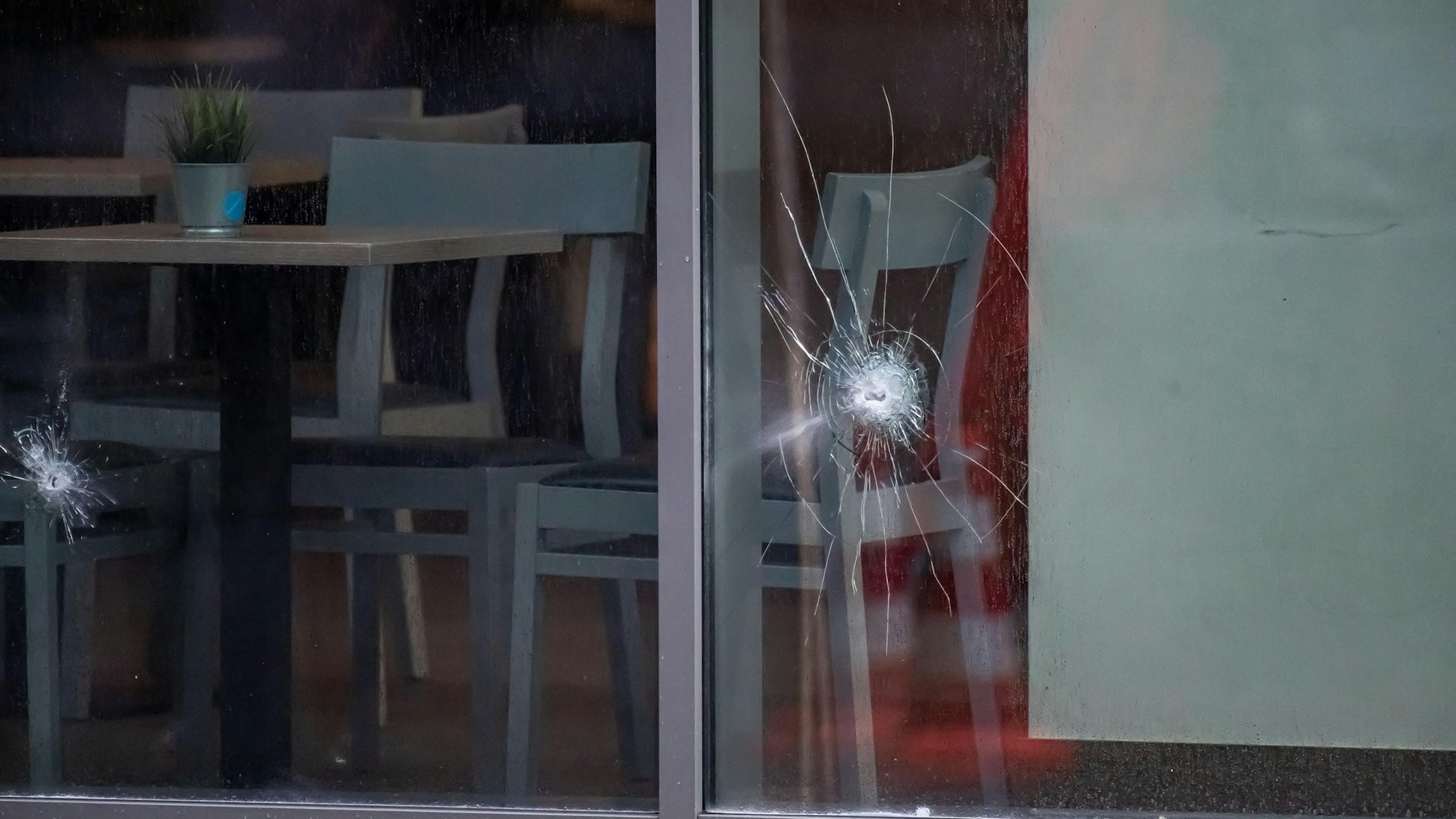 In einer Fensterscheibe sind Einschusslöcher zu sehen.