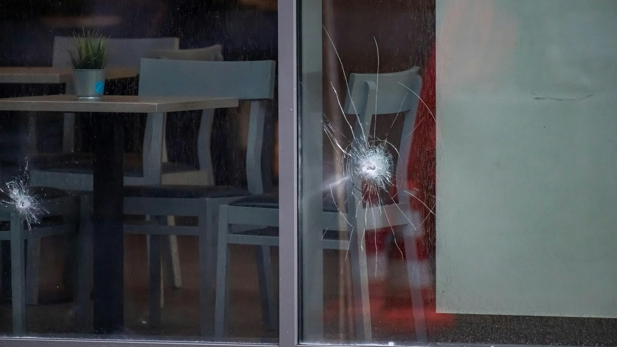 In einer Fensterscheibe sind Einschusslöcher zu sehen.