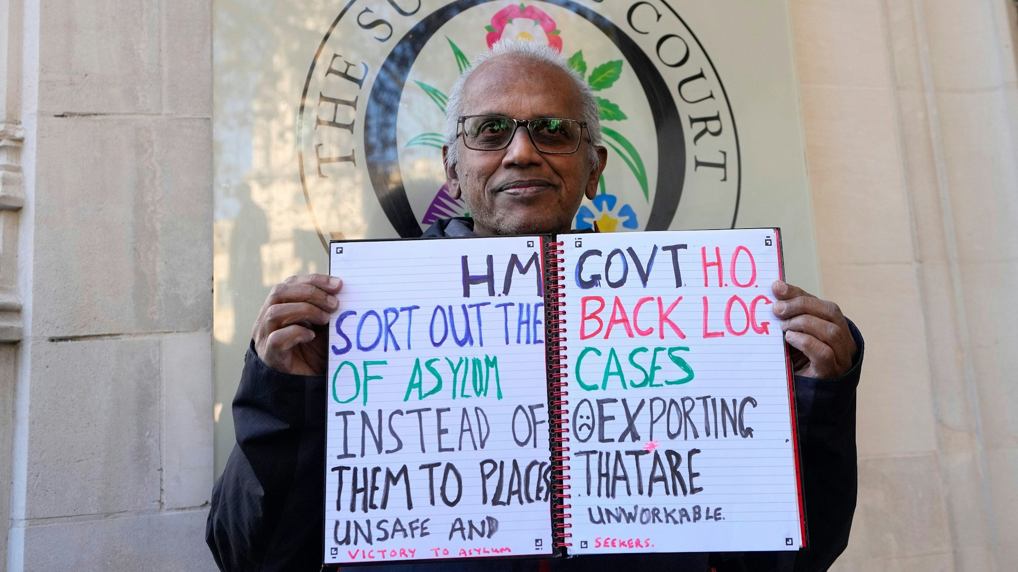 15.11.2023, Großbritannien, London: Ein Demonstrant steht vor dem Obersten Gerichtshof. Die britische Regierung ist vor Gericht mit ihren Plänen gescheitert, Asylbewerber nach Ruanda abzuschieben. Das Oberste Gericht in London nannte das Vorhaben am Mittwoch, 15.11.2023, rechtswidrig. Foto: Kirsty Wigglesworth/AP +++ dpa-Bildfunk +++