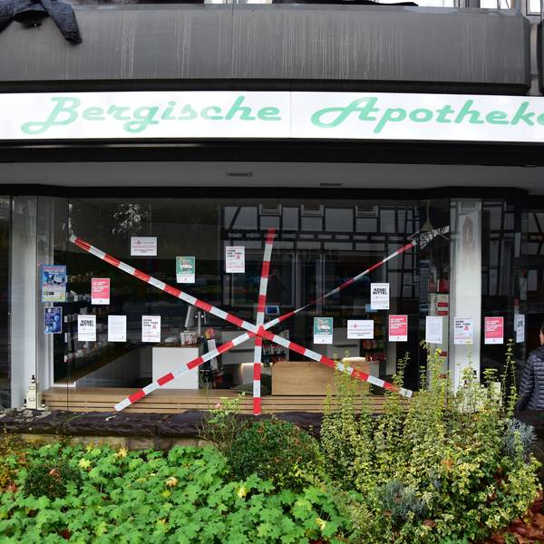 Bergische Apotheke in Much. Rotweißes Flatterband ist kreuz und quer vor das Schaufenster gespannt.